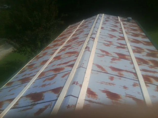 Rusted metal roof panels with new wood purlins before replacement — Storm Damage Roof Repair in Cummings by Roofing Brothers